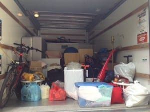 Belongings are packed in the back of a moving truck.